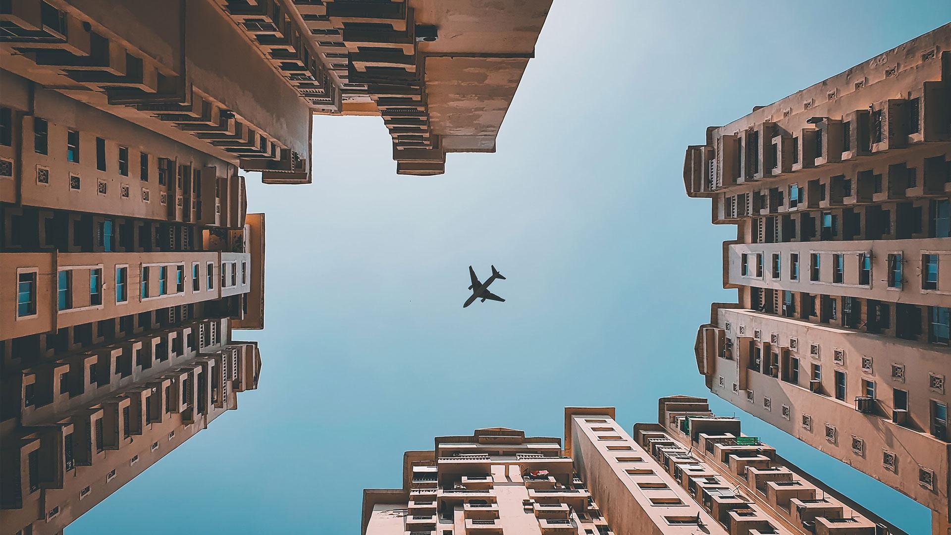 an airplane flying over skyscrapers